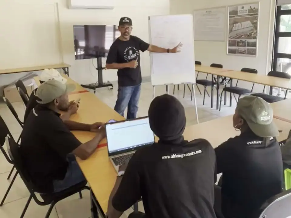 A trainer leading a classroom session with young people at their laptops